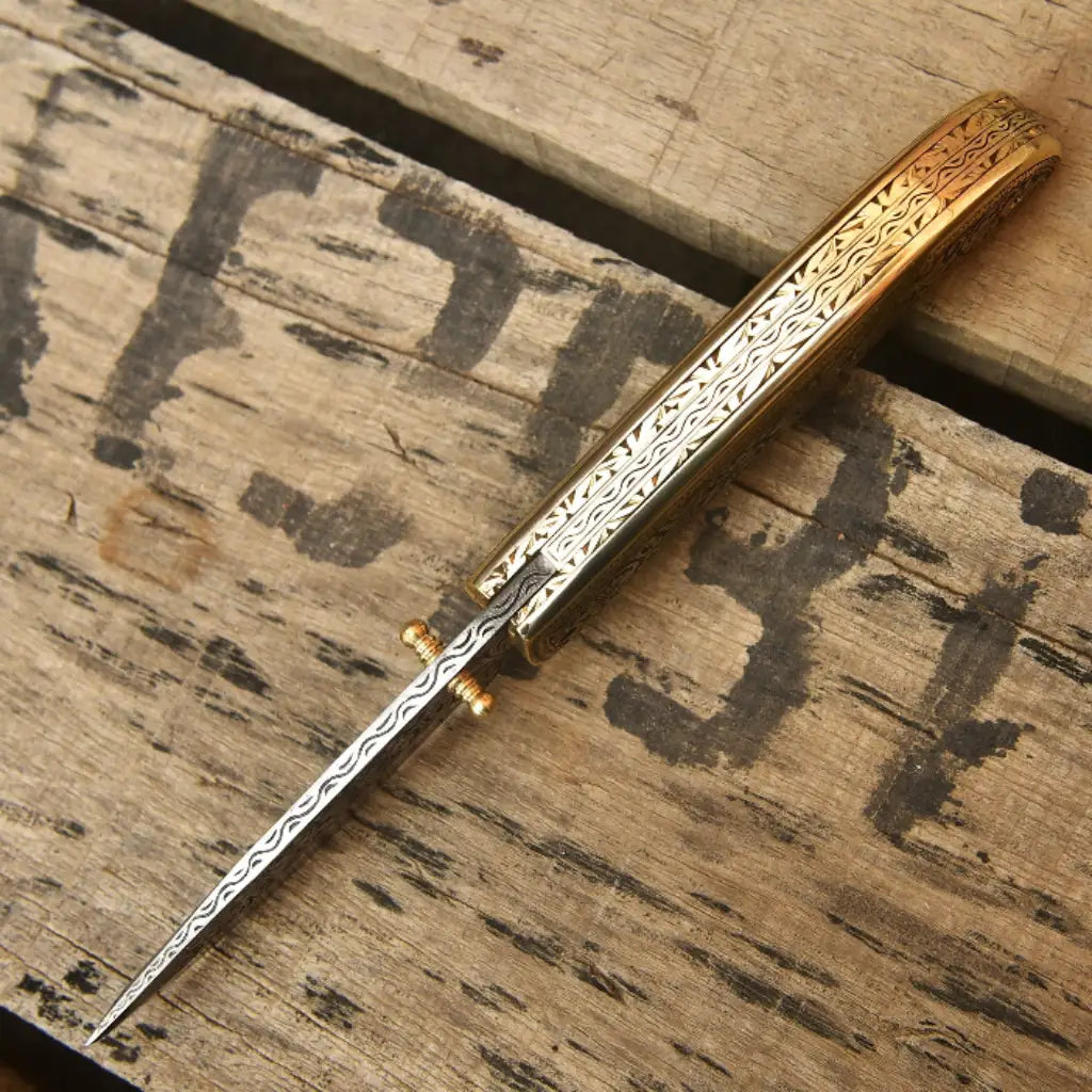 Custom engraved Damascus steel folding pocket knife spine filework detail with brass thumb stud and gold floral handle scale USA