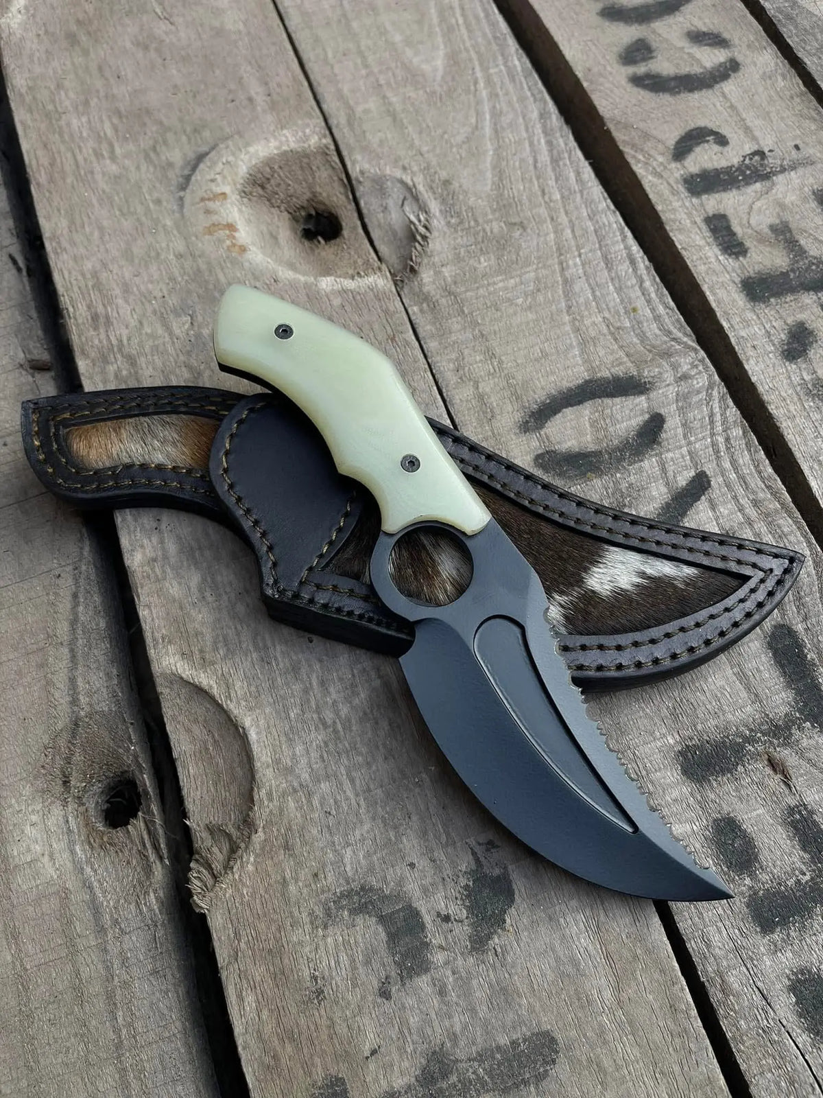 Handmade D2 steel finger hole knife with black powder coat blade and hair-on cowhide sheath - full view