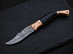 Engraved copper bolster floral design detail on Damascus folding knife