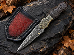 Handmade Damascus folding knife with hand-engraved brass bolsters, carved wood handle, brass thumb stud and red leather sheath - full view