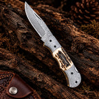 Handmade Damascus folding knife with stag antler handle and raindrop pattern - full view