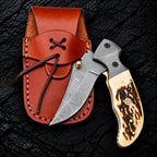 Damascus steel clip point blade with brass thumb stud close-up