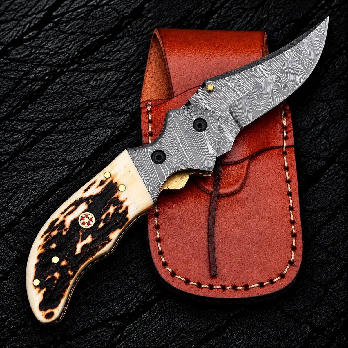 Damascus bolsters with screws and brass liners on liner lock folding knife