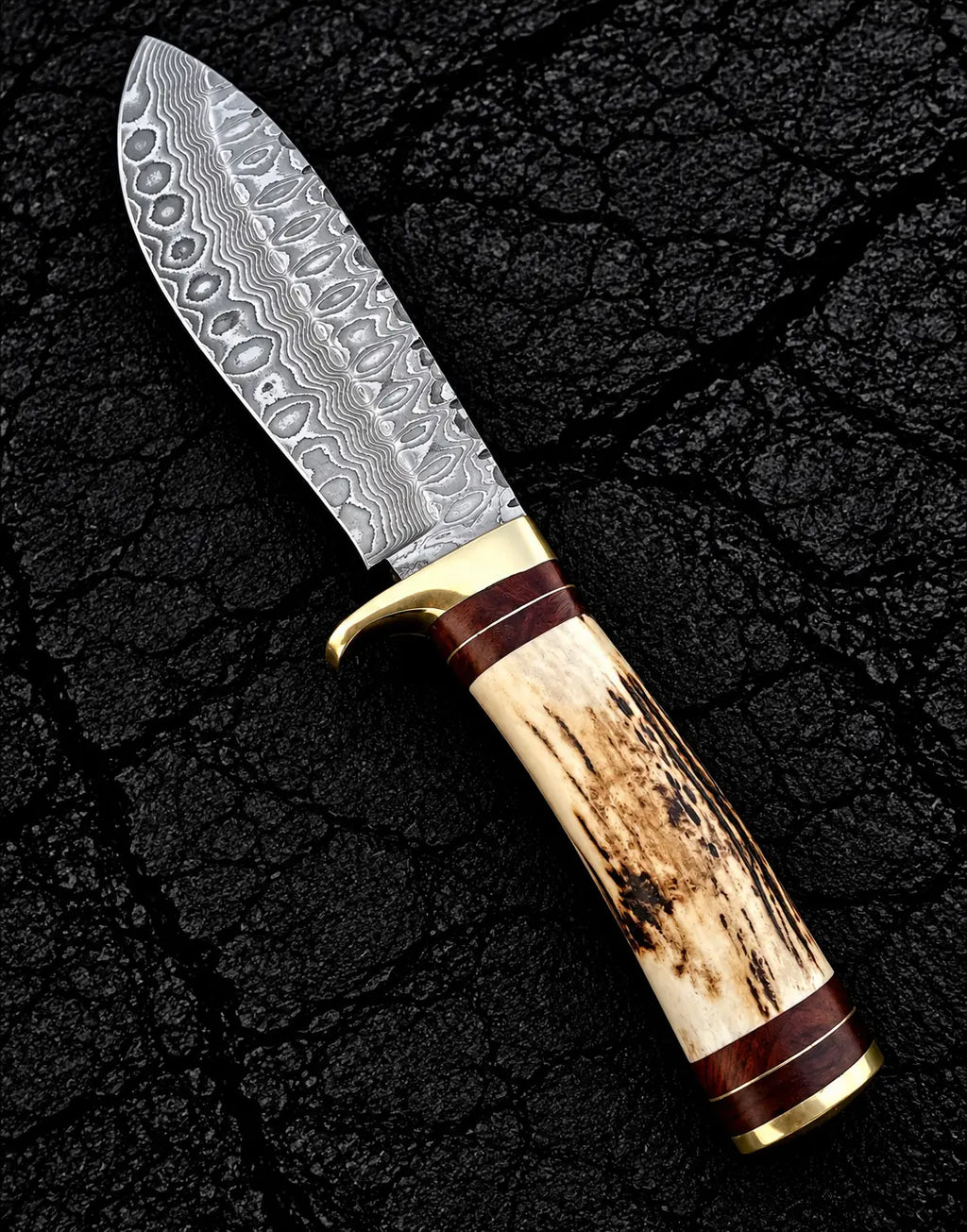 Stag antler handle with brass guard and wood spacer detail on Damascus knife