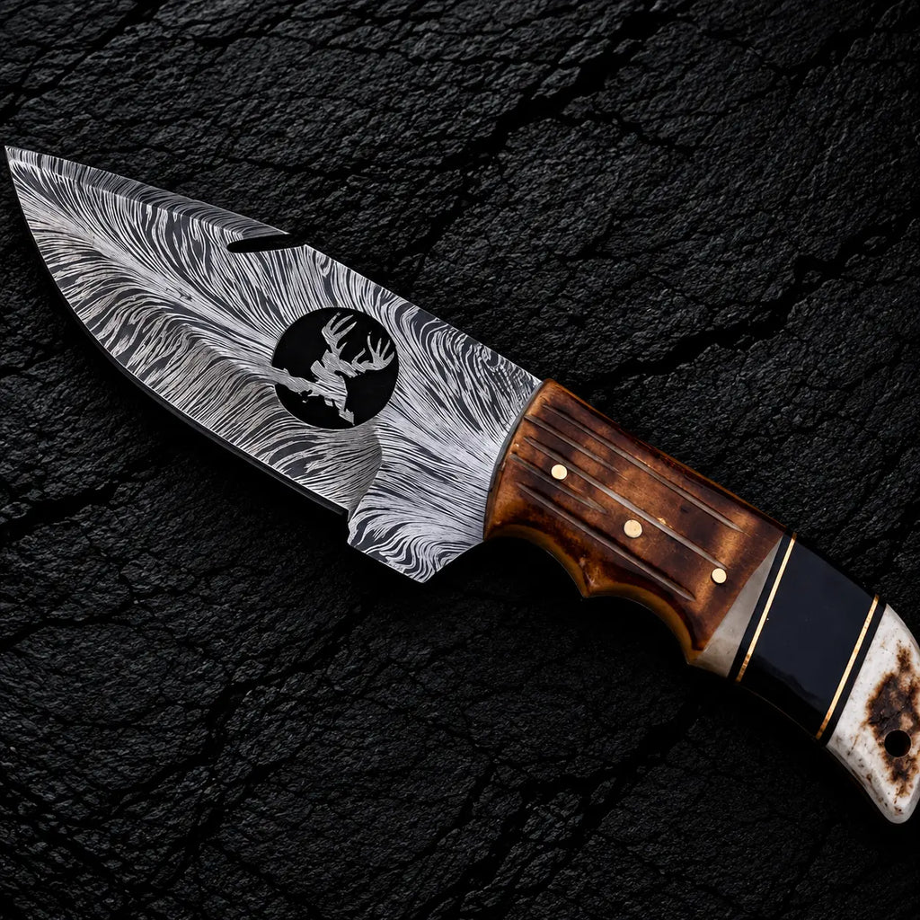 Feather Damascus blade with wire-cut deer head design and gut hook close-up