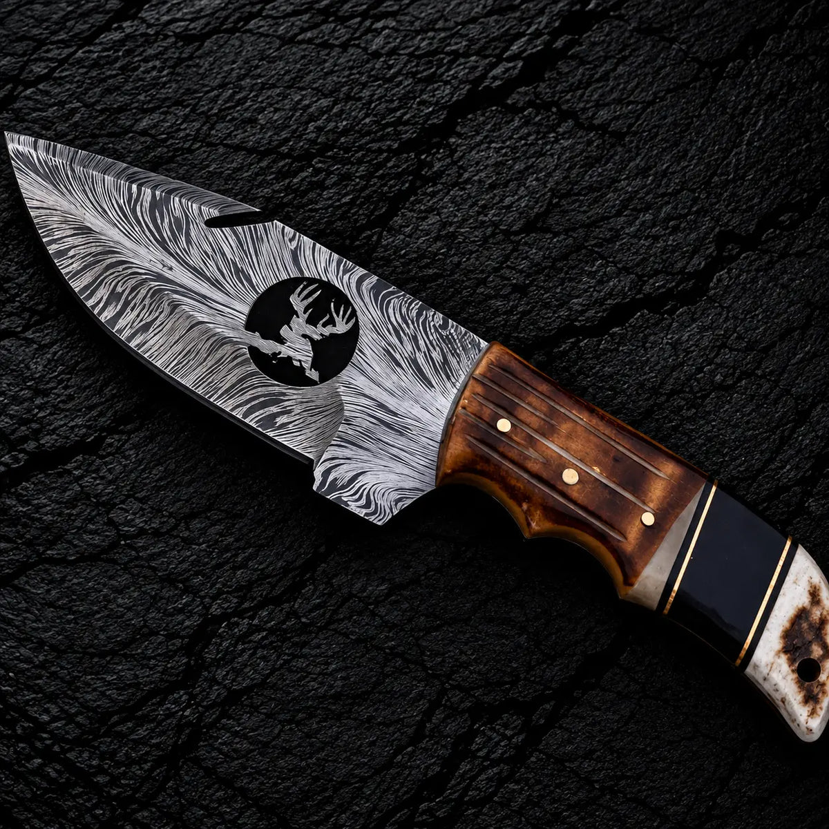 Feather Damascus blade with wire-cut deer head design and gut hook close-up