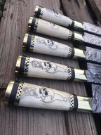 Hand-engraved skull handle detail on Damascus steel knife set