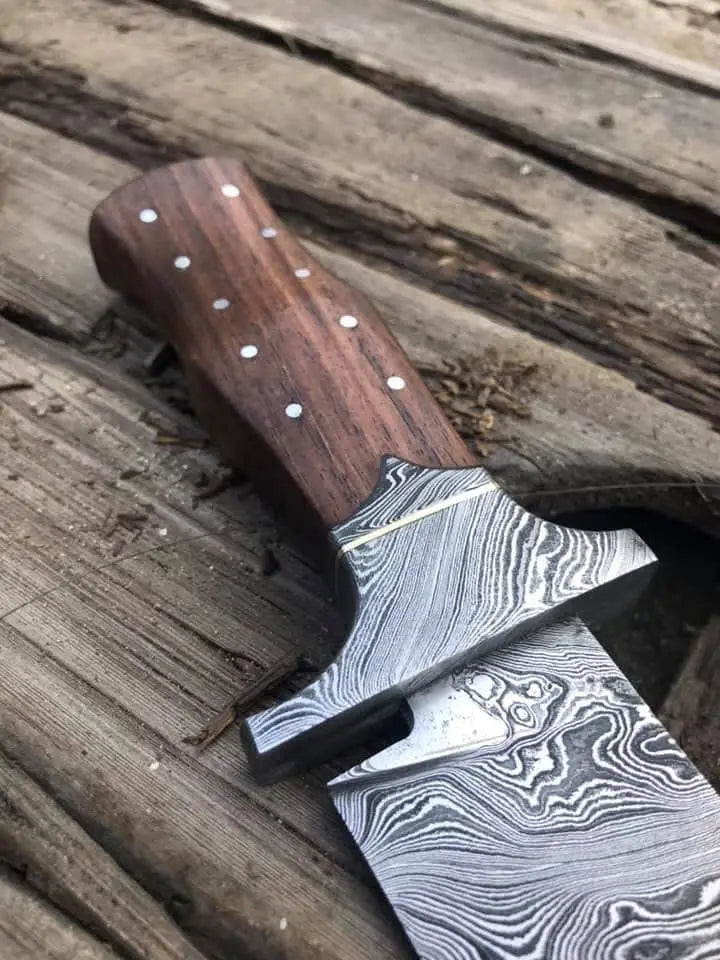 Damascus steel bowie knife on wood background - full length view