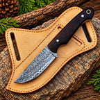 Damascus steel cowboy knife on rock background - side angle