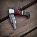 Close-up of hand-forged Damascus steel folding knife blade pattern