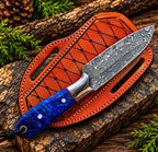 Damascus steel skinner knife on wood background - side angle