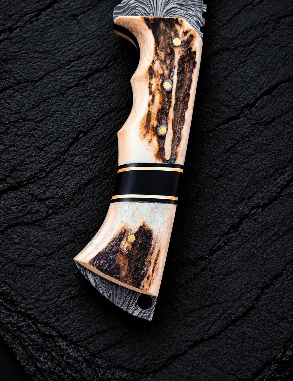 Feather Damascus blade pattern with wire-cut deer head design close-up