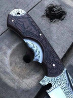 Hand engraved Bowie skinner knife on wood background