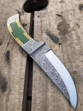 Green stone and gold brass handle detail on engraved dagger