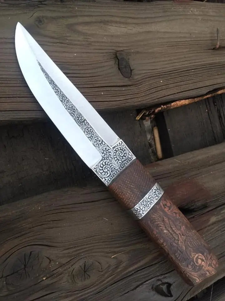 Scrollwork engraved blade close-up on fixed blade knife