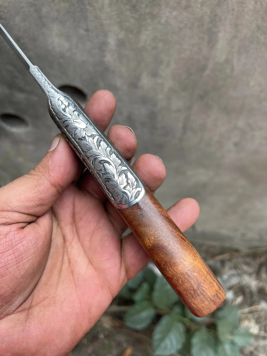 Hand engraved fixed blade knife held in hand - full length view