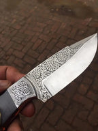 Scrollwork engraved blade close-up on full tang skinner knife