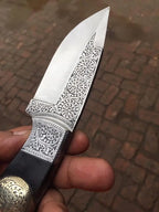 Engraved brass medallion detail on skinner knife handle