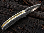 Hand engraved steel folding knife closed - side view