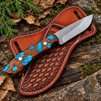 Turquoise stone cluster skinner knife on rock background - side angle