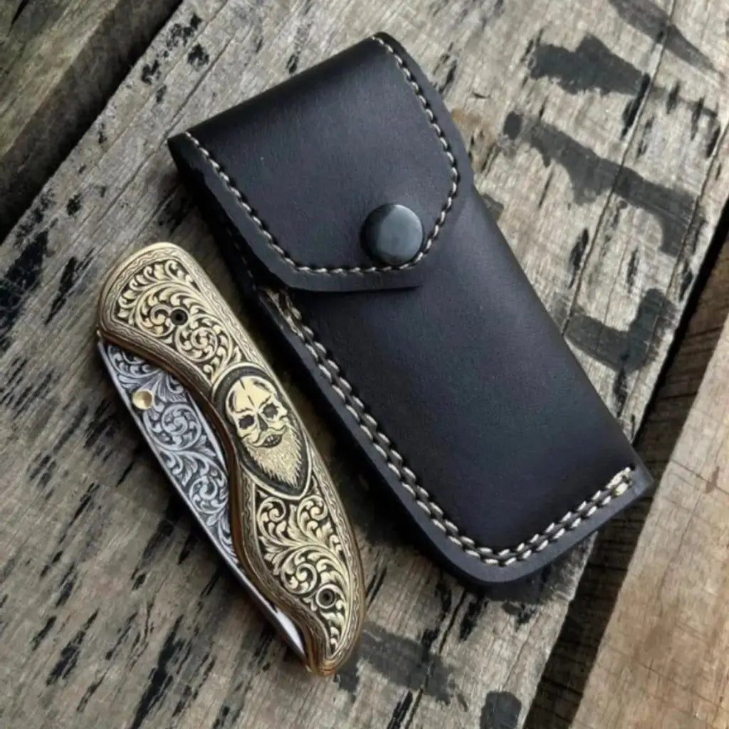 Skull handle folding pocket knife open on wood background