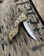 Close-up of skull handle design on folding knife