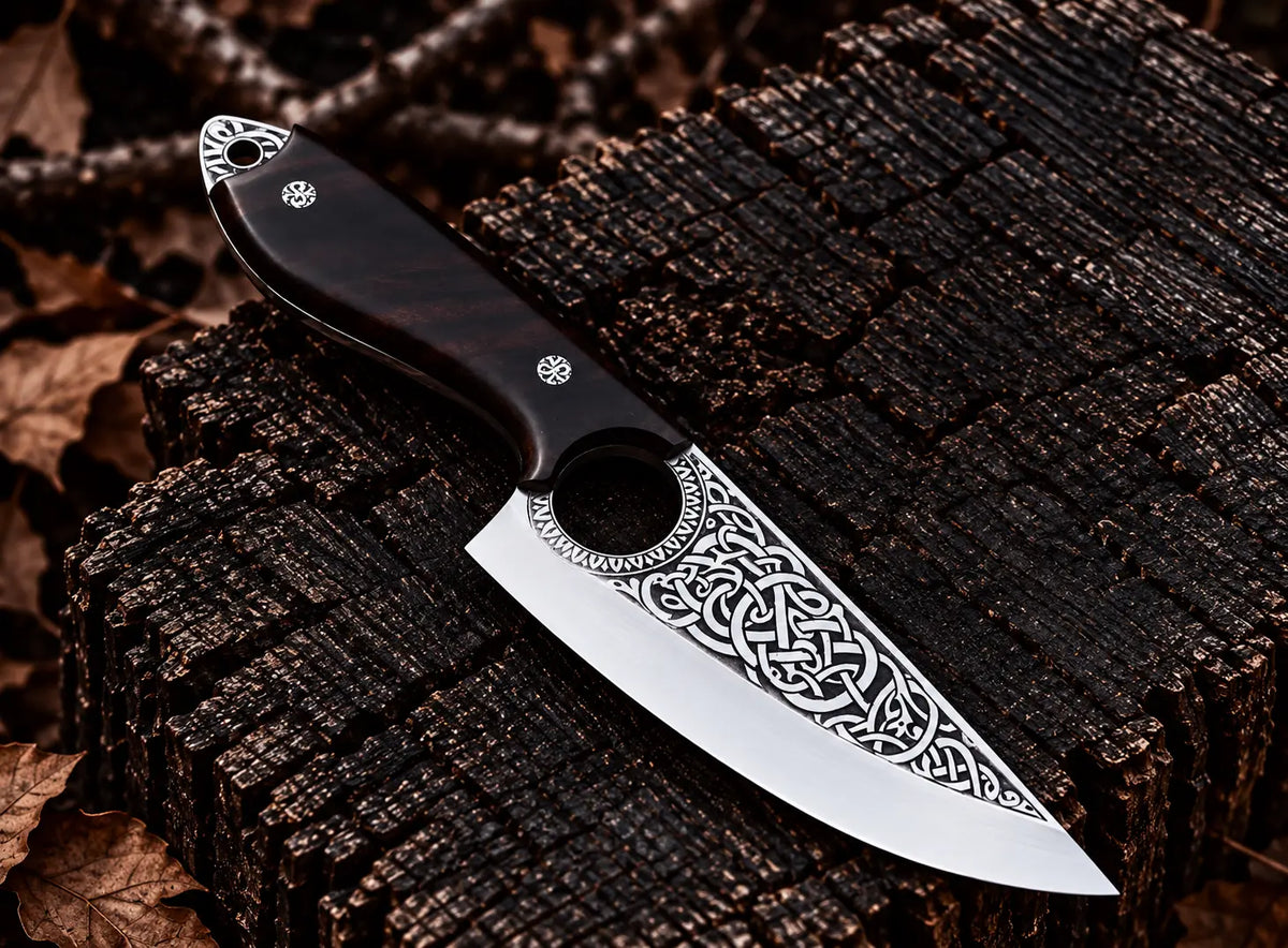 Hand engraved Viking Celtic knotwork on mirror polished skinner knife blade with finger hole close-up